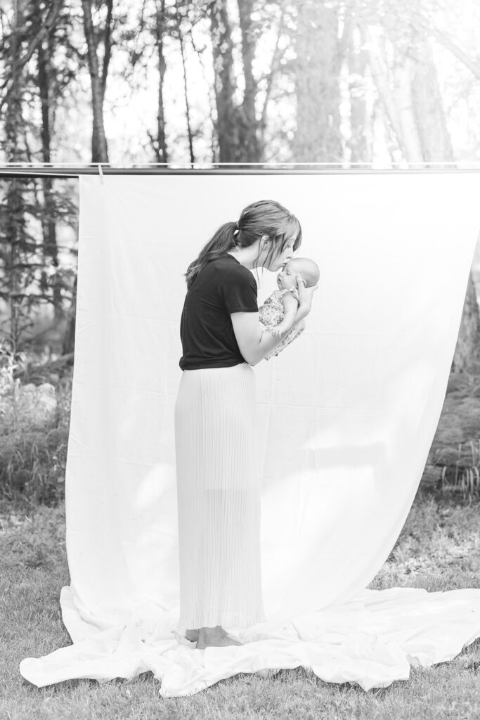 black and white photo of mother holding her baby outdoors